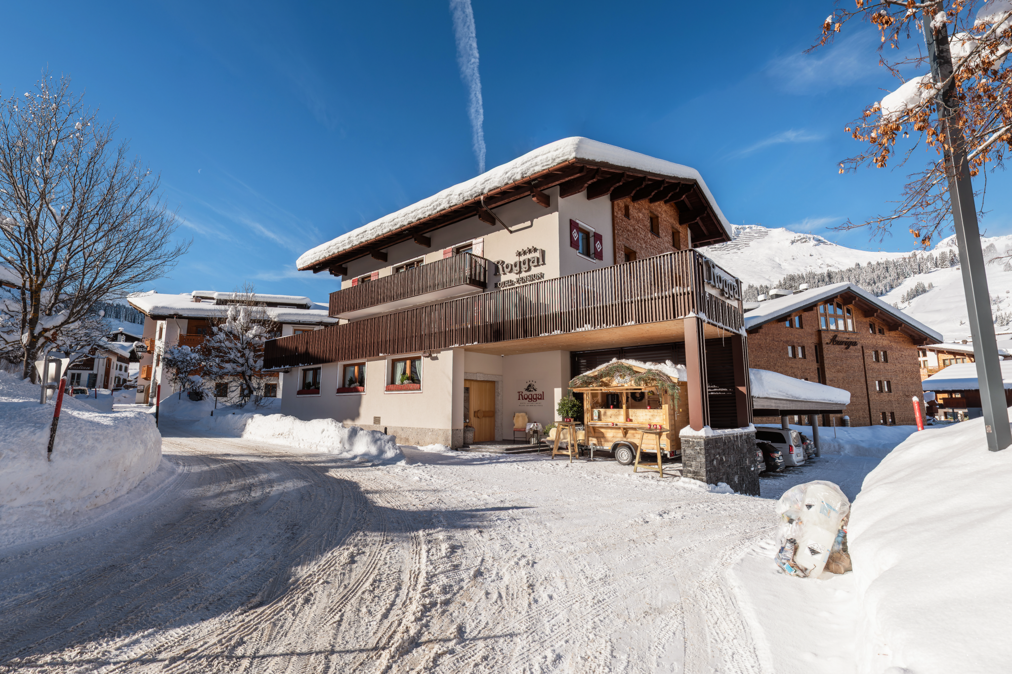 Hotel Roggal Eingang mit Schnee und Punsch Hütte Lech am Arlberg